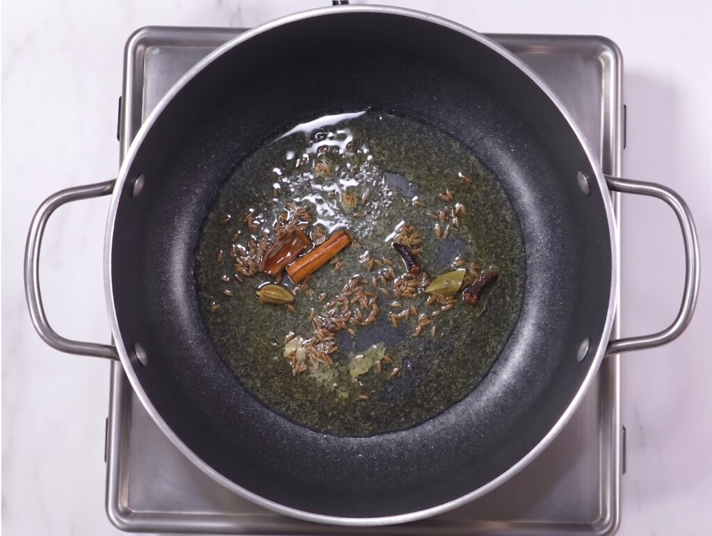 Authentic palak paneer recipe showing whole spices tempering in oil