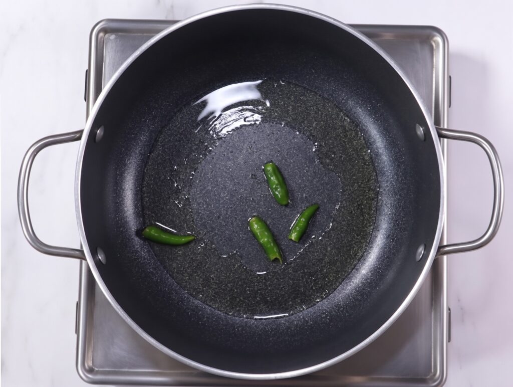 Palak paneer recipe step by step showing green chillies sautéing in oil